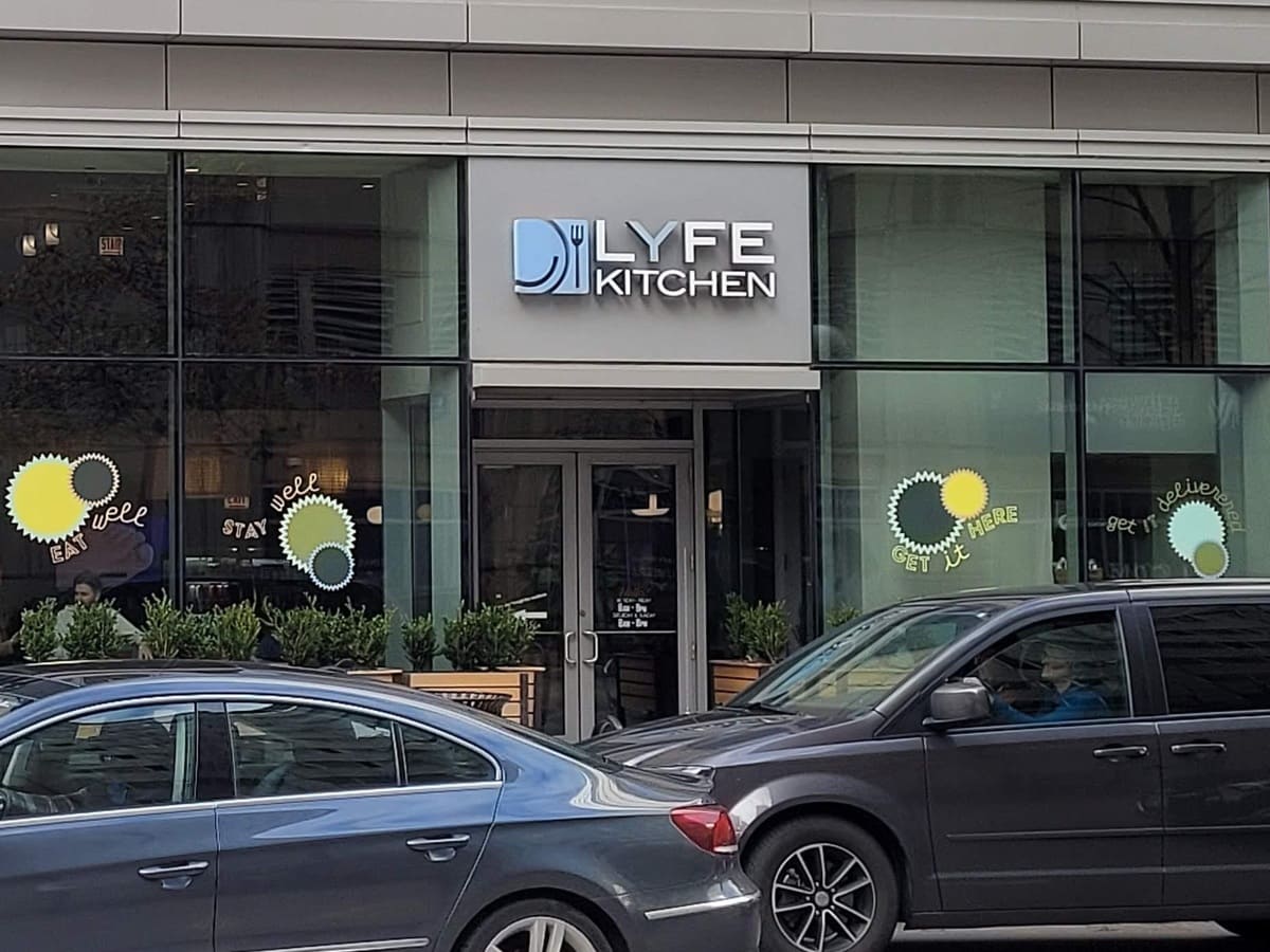 A car parked in front of a building with a sign that says lyfe kitchen.