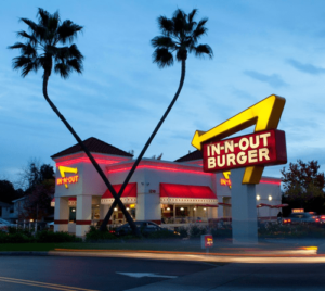 An in-out burger restaurant is lit up at dusk.