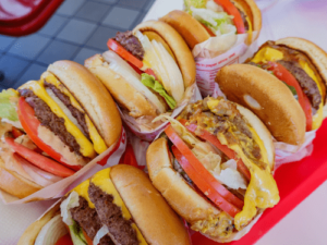 Five burgers on a tray.