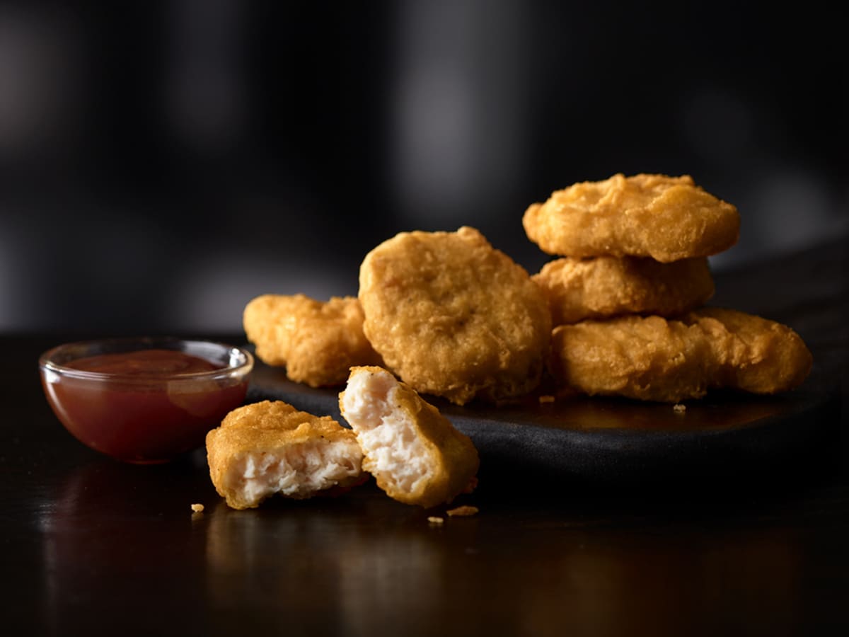 High Protein McDonald's fried chicken nuggets on a plate with dipping sauce.