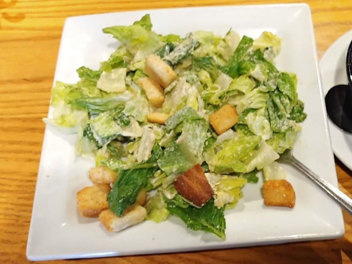A plate of caesar salad with croutons and croutons.