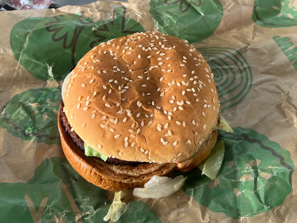 A Burger KIng burger sitting on top of a piece of paper.