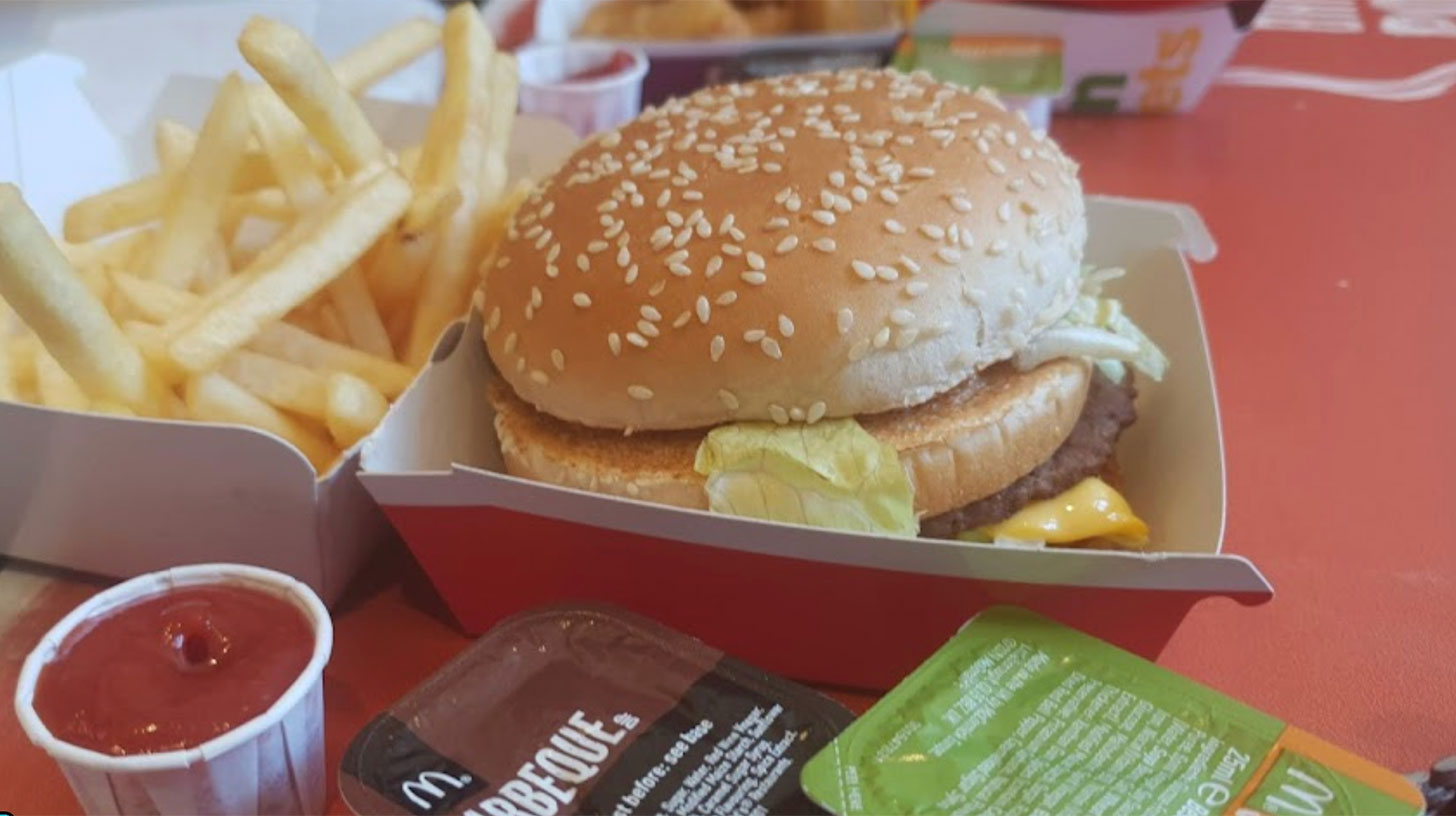 A mcdonald's burger with fries and ketchup.