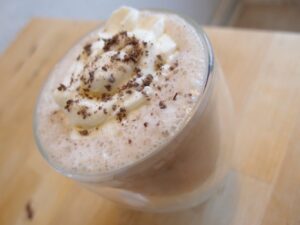 A chocolate drink with whipped cream and chocolate sprinkles.