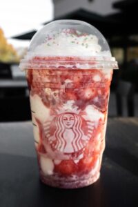 A starbucks strawberry milkshake sitting on a table.