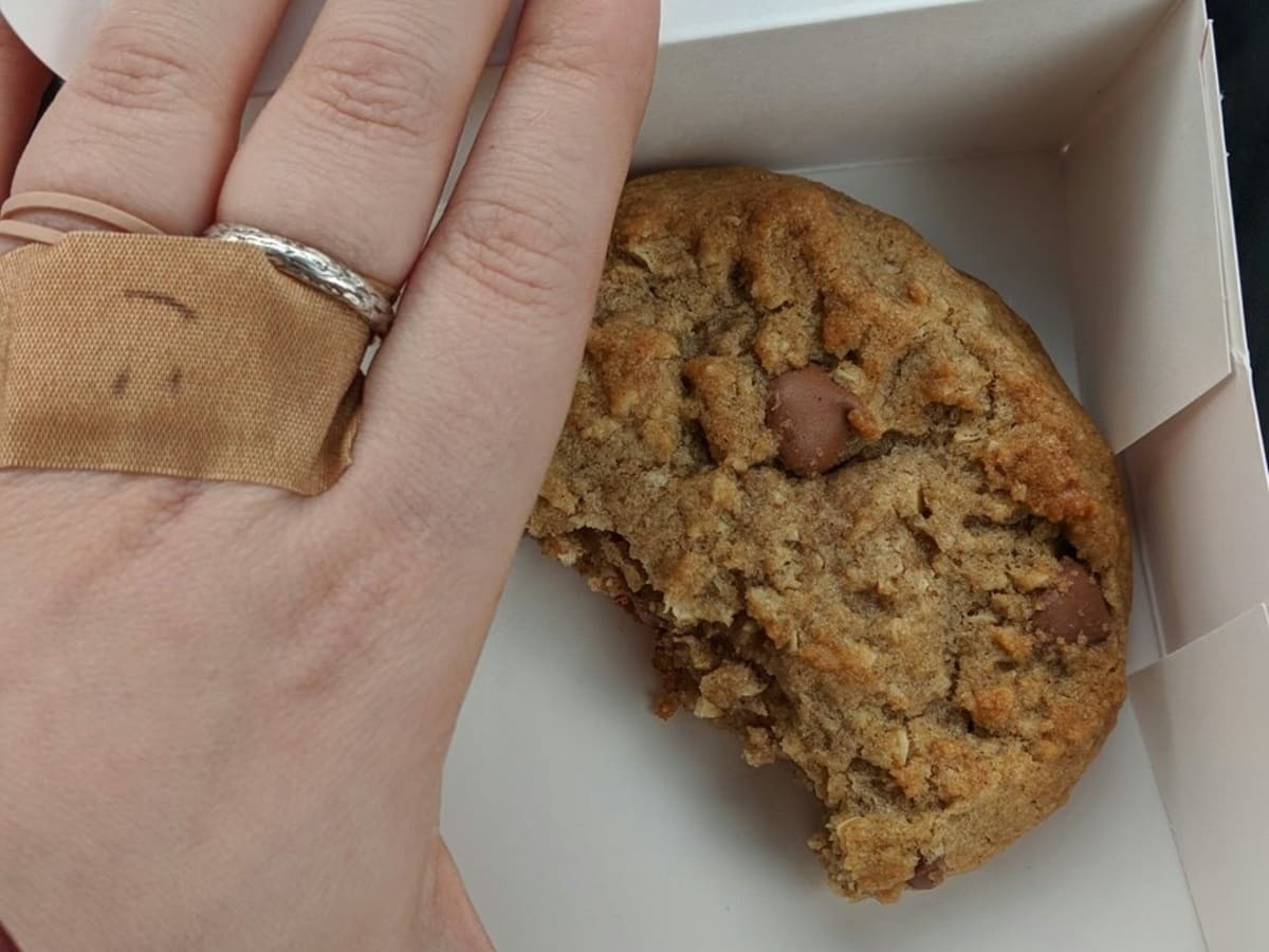 A person holding a Crumbl cookie