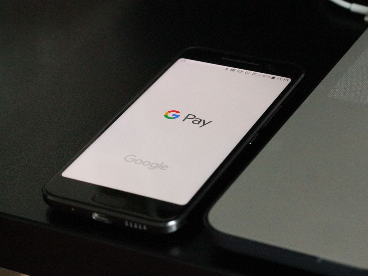 A phone with the Google Pay logo on it sitting on a table, demonstrating contactless payment.