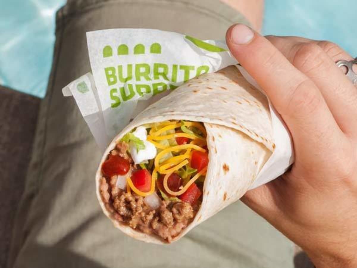 Taco Bell offering breakfast hours with a person holding a burrito supreme wrap.