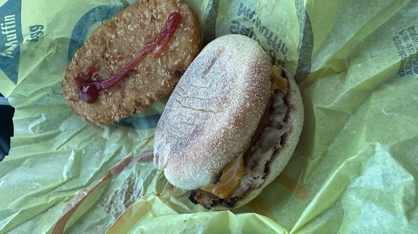 A mcdonald's breakfast sandwich with ketchup and mustard.