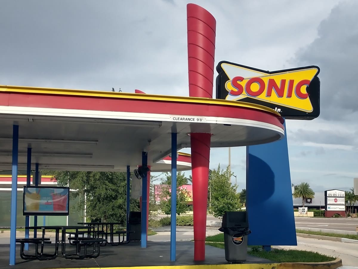 A heart healthy Sonic fast food restaurant with a blue and yellow sign.