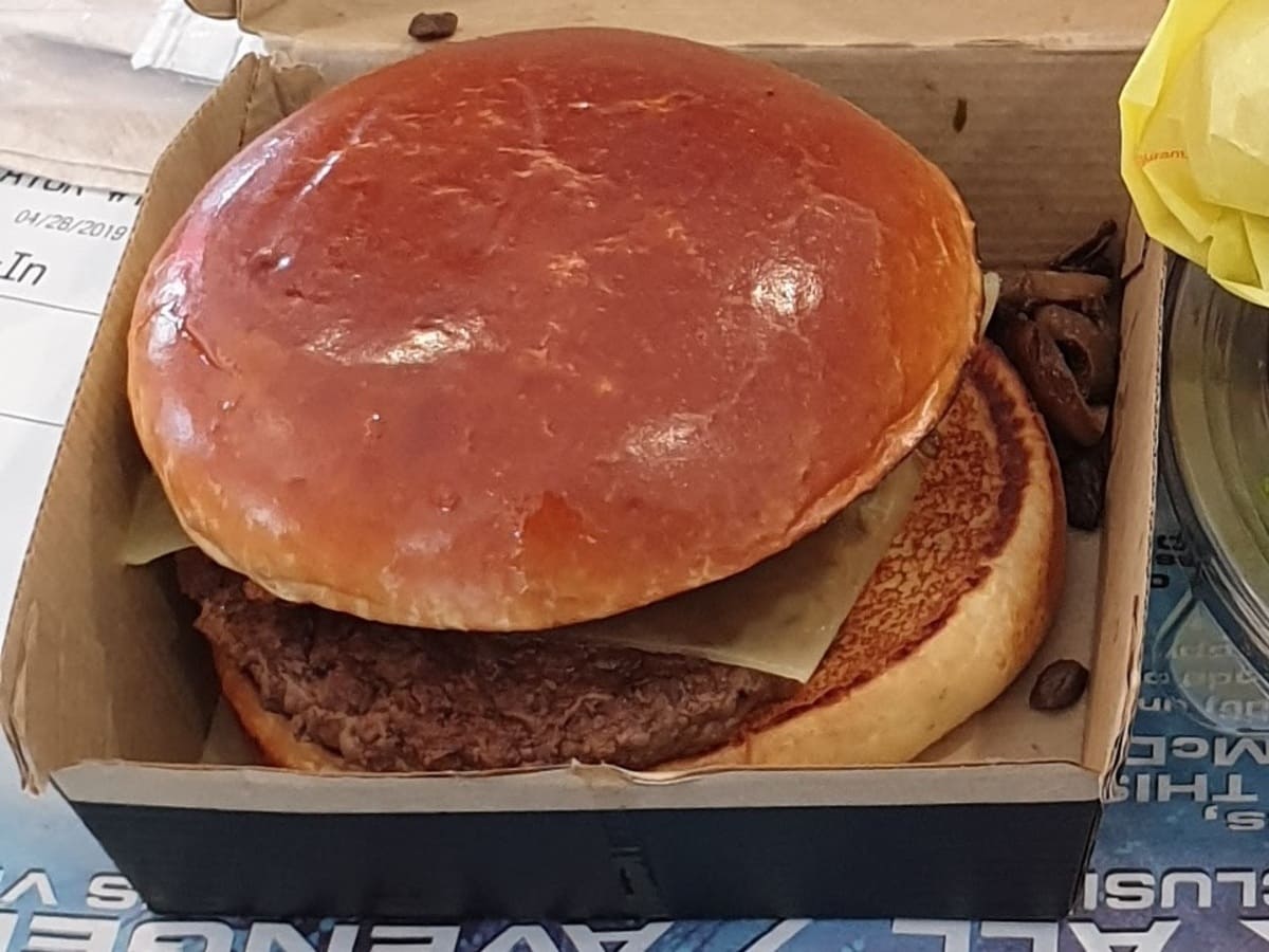 A burger sitting in a box on a table.